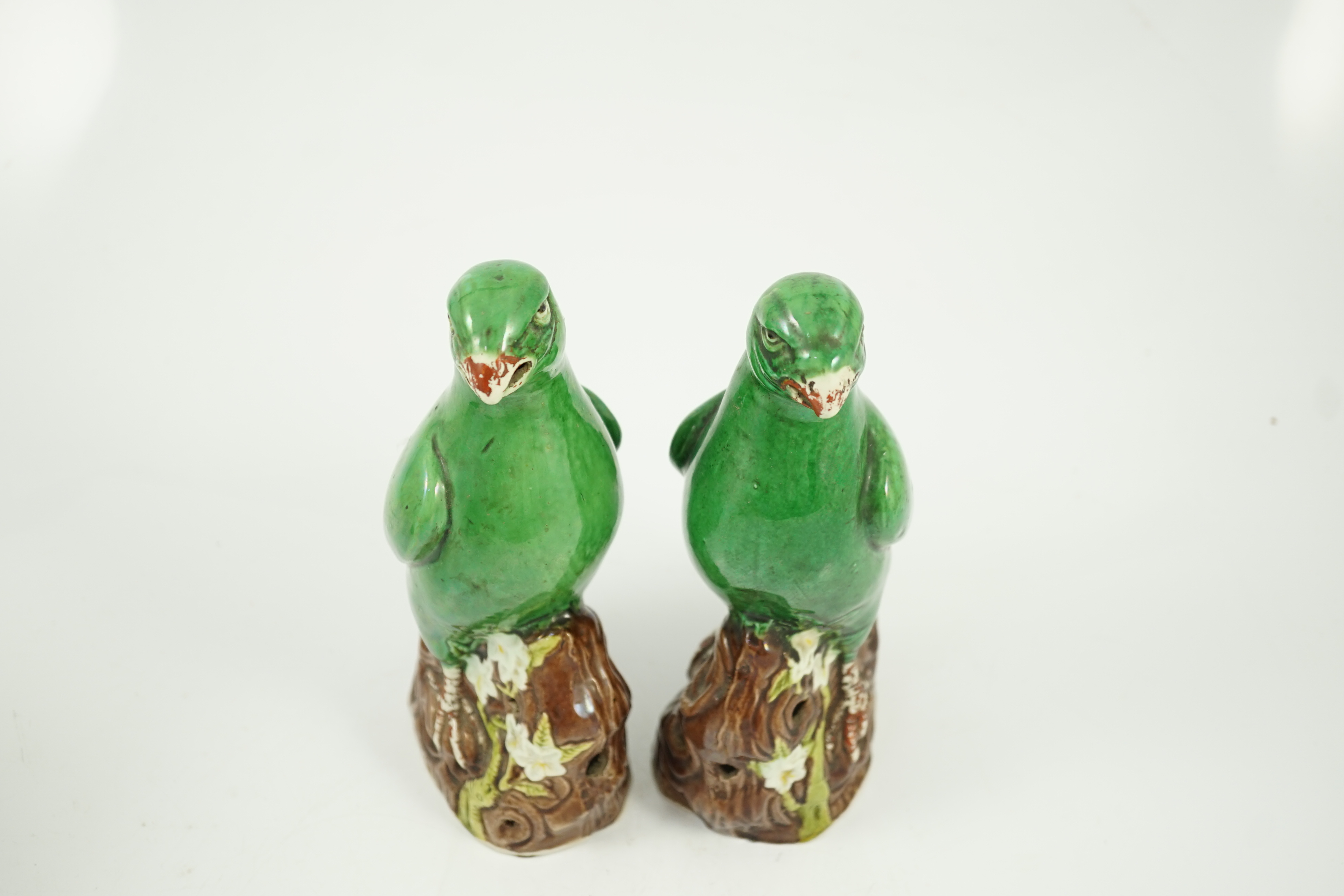 A pair of Chinese green glazed models of parrots, Kangxi period, hairline cracks to one tail feather